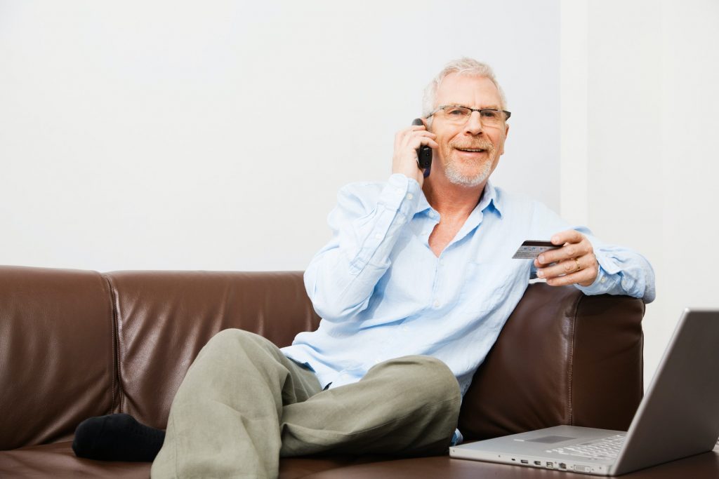 Mature man using calling to a contact center for financial services